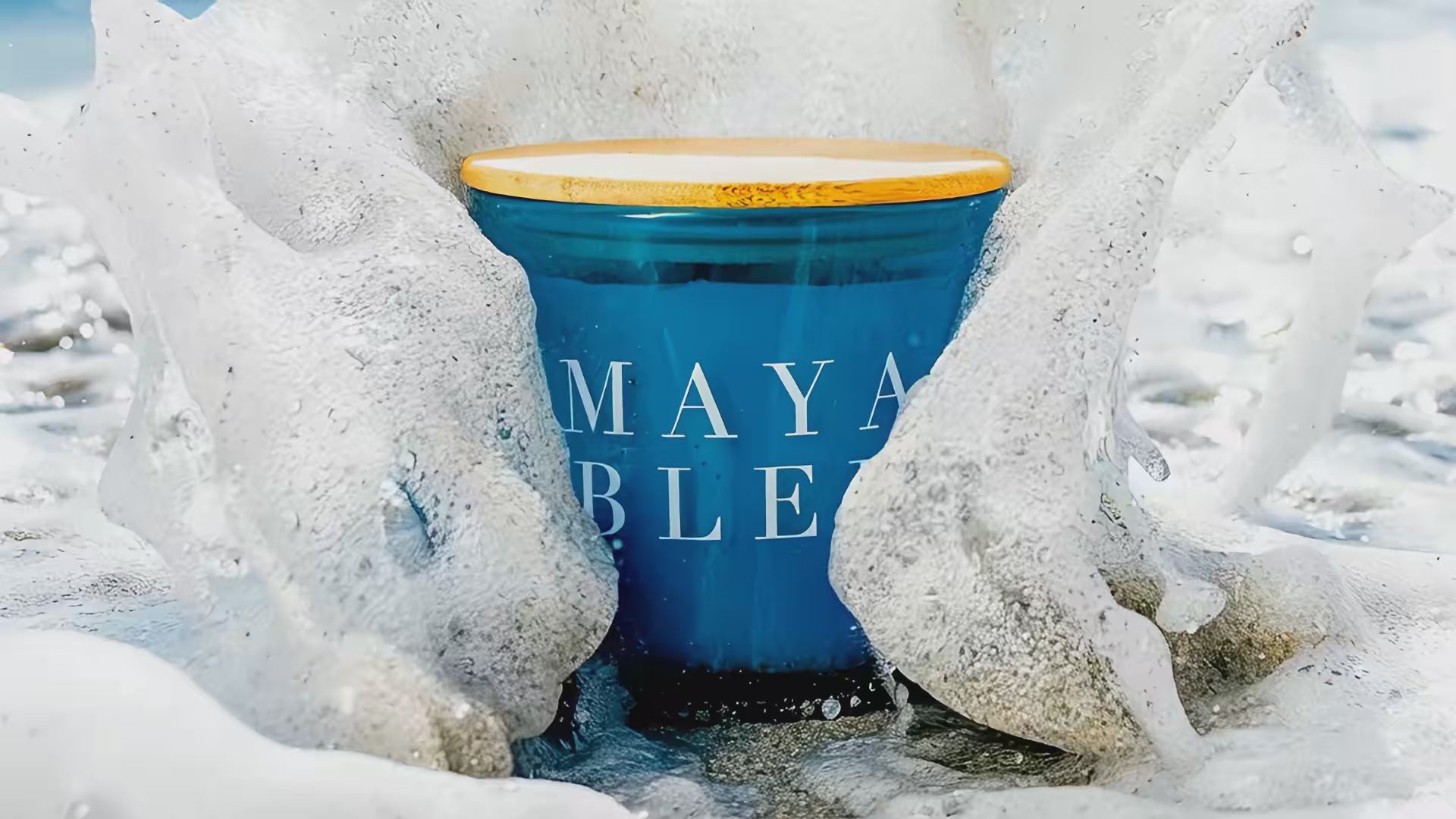A video showcasing a blue Maya Bleu candle being engulfed by a wave.